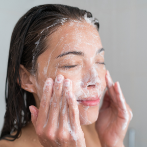 mulher lavando o rosto com sabonete de skin care